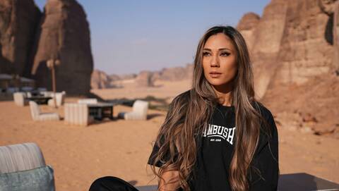 Manda Moor in a desert setting with rock formations in the background, captured in a contemplative outdoor portrait.