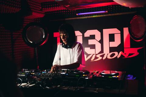 Janina performing at her Triplevisions residency in Sigma Club Ibiza, surrounded by DJ equipment and underground club vibes.